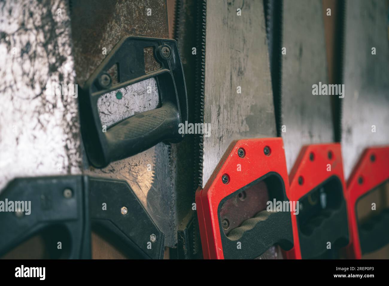 primo piano i vecchi denti affilati usati della sega a mano ruggine per impieghi pesanti taglio del legno per la casa attrezzi fai da te appendere in officina. Foto Stock