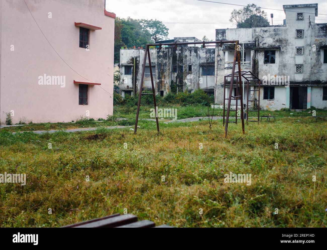 Parco di quartiere vuoto e logoro con seghe arrugginite e rotte per bambini. Tema grunge. India. Foto Stock