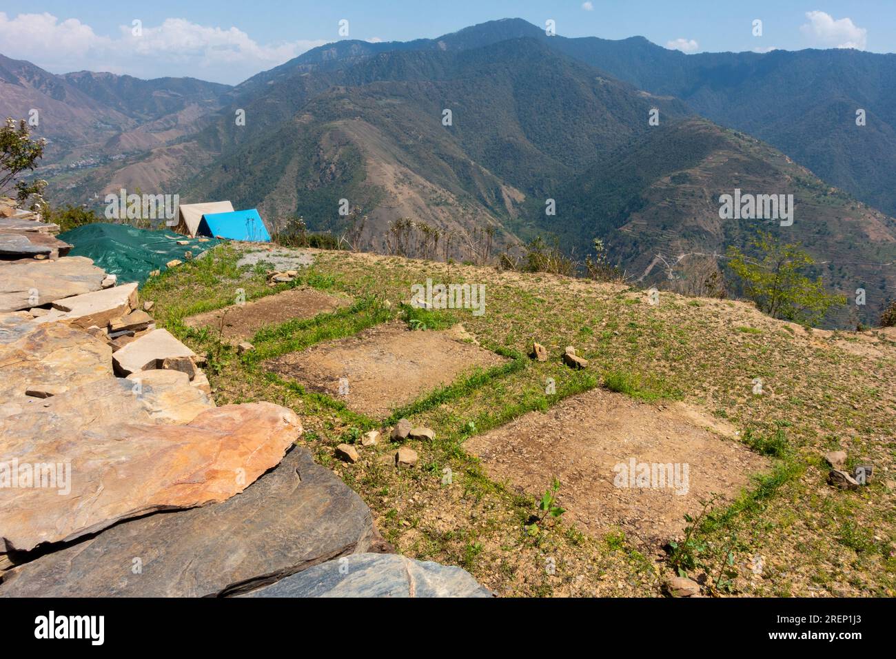 Cicatrici del campeggio: Danni al terreno erboso e impronte sull'erba dopo il campeggio. Campeggio in cima a una collina circondato dalla catena montuosa di Shivalik. Regione himalayana in UTT Foto Stock