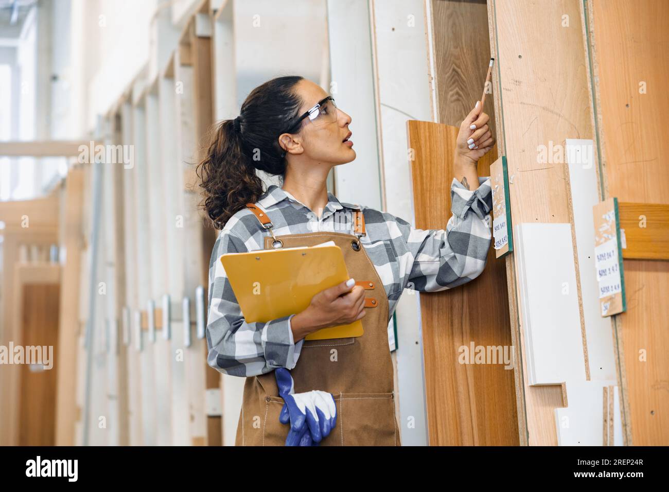 personale che lavora nell'industria del mobile in legno fabbrica che controlla la scelta del materiale del tipo di legno compensato in magazzino. Foto Stock personale che lavora nell'industria del mobile in legno fabbrica che controlla la scelta del materiale del tipo di legno compensato in magazzino. Foto Stock