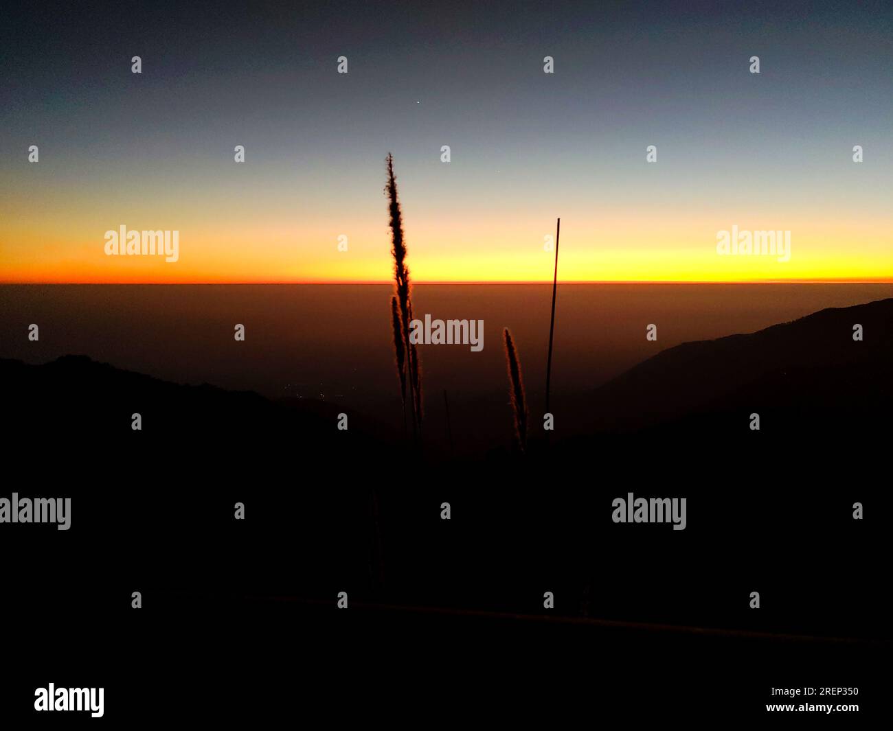 Esotico scatto a 180 gradi della linea invernale arancione con silhouette da montagna a Mussoorie, Uttarakhand, India. Splendido scenario invernale. Foto Stock