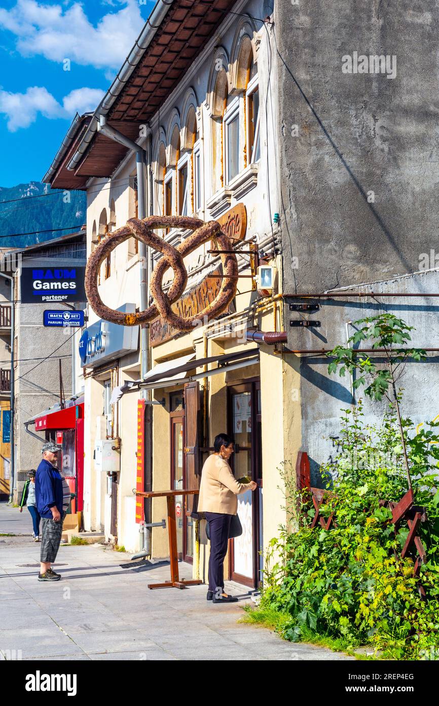Donna che fa shopping in un negozio rumeno di pretzel, Busteni, Romania Foto Stock
