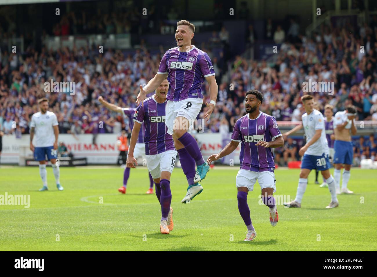 29 luglio 2023, bassa Sassonia, Osnabrück: Calcio: 2nd Bundesliga, VfL Osnabrück - Karlsruher SC, giorno 1 allo Stadion an der Bremer Brücke. Il marcatore gol di Osnabrück Erik Engelhardt (centro) celebra il suo obiettivo di raggiungere il 1-1 con Lukas Kunze (l) e Noel Niemann (r). Foto: Friso Gentsch/dpa - NOTA IMPORTANTE: In conformità ai requisiti della DFL Deutsche Fußball Liga e del DFB Deutscher Fußball-Bund, è vietato utilizzare o far utilizzare fotografie scattate nello stadio e/o della partita sotto forma di immagini di sequenza e/o serie di foto simili a video. Foto Stock