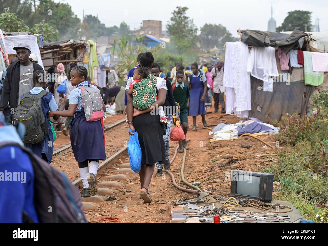KENYA, Nairobi, Kibera Slum, passeggio lungo la ferrovia, tessuti e rottami elettronici in vendita / KENIA, Nairobi, Slum Kibera, Fußgänger auf Bahnlinie Foto Stock