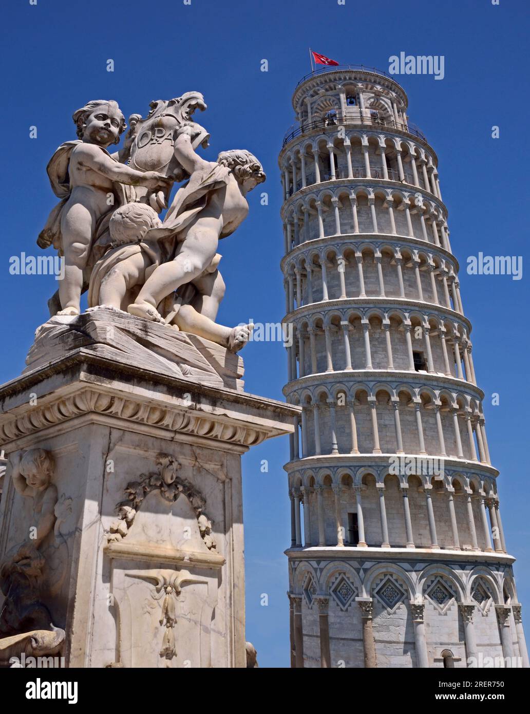 Pisa, Italia - 21 maggio 2016: La famosa Torre Pendente di Pisa con una statua vicina su sfondo blu chiaro. Foto Stock