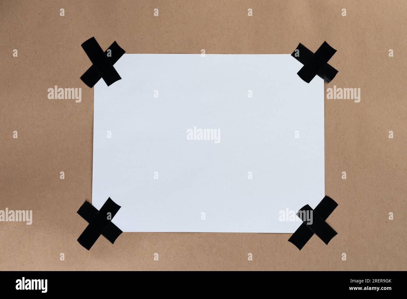 Foglio di carta bianco vuoto incollato alla vista ravvicinata su sfondo marrone Foto Stock