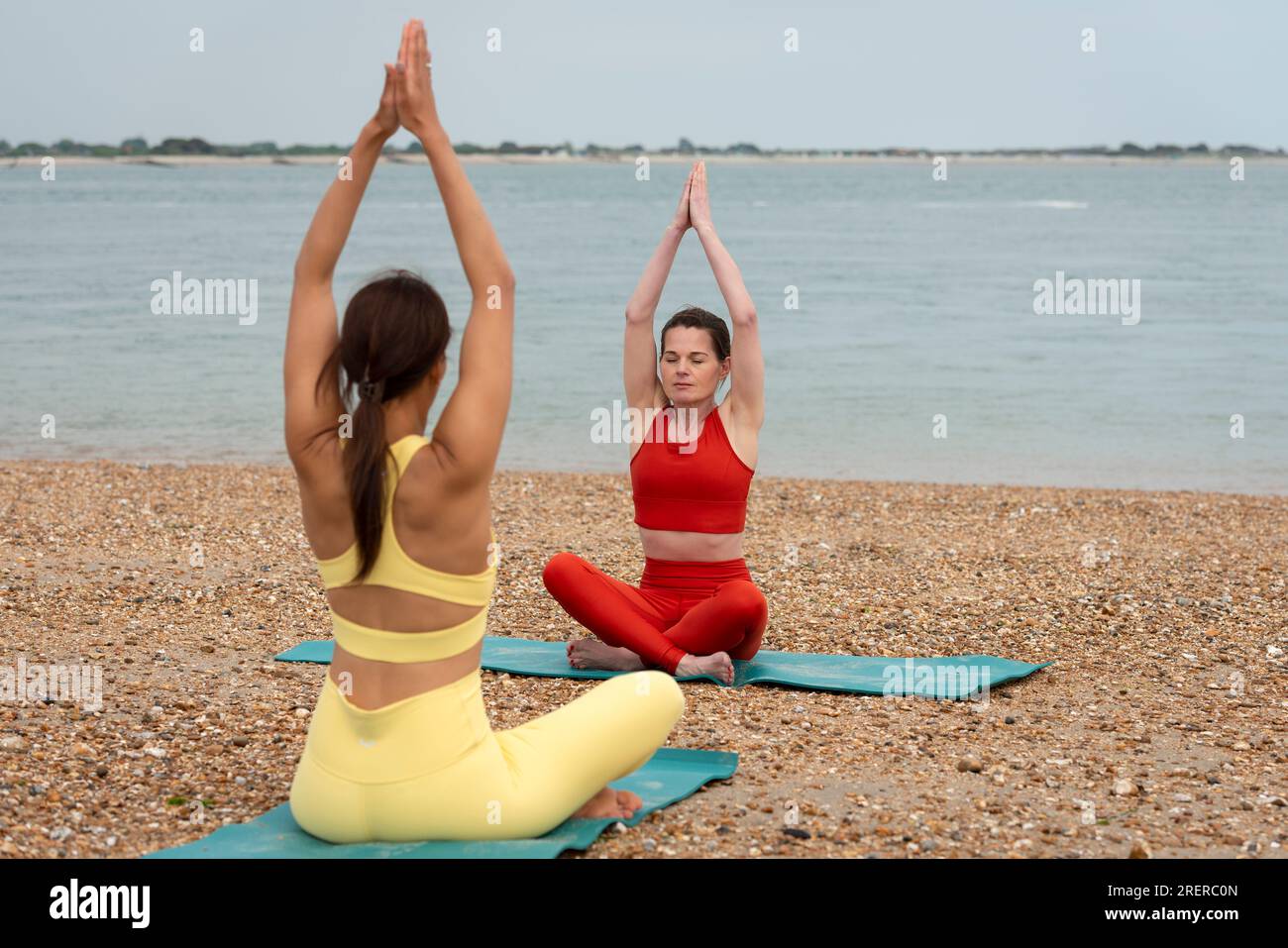 Lezione di meditazione di yoga sulla spiaggia. Due donne. Foto Stock