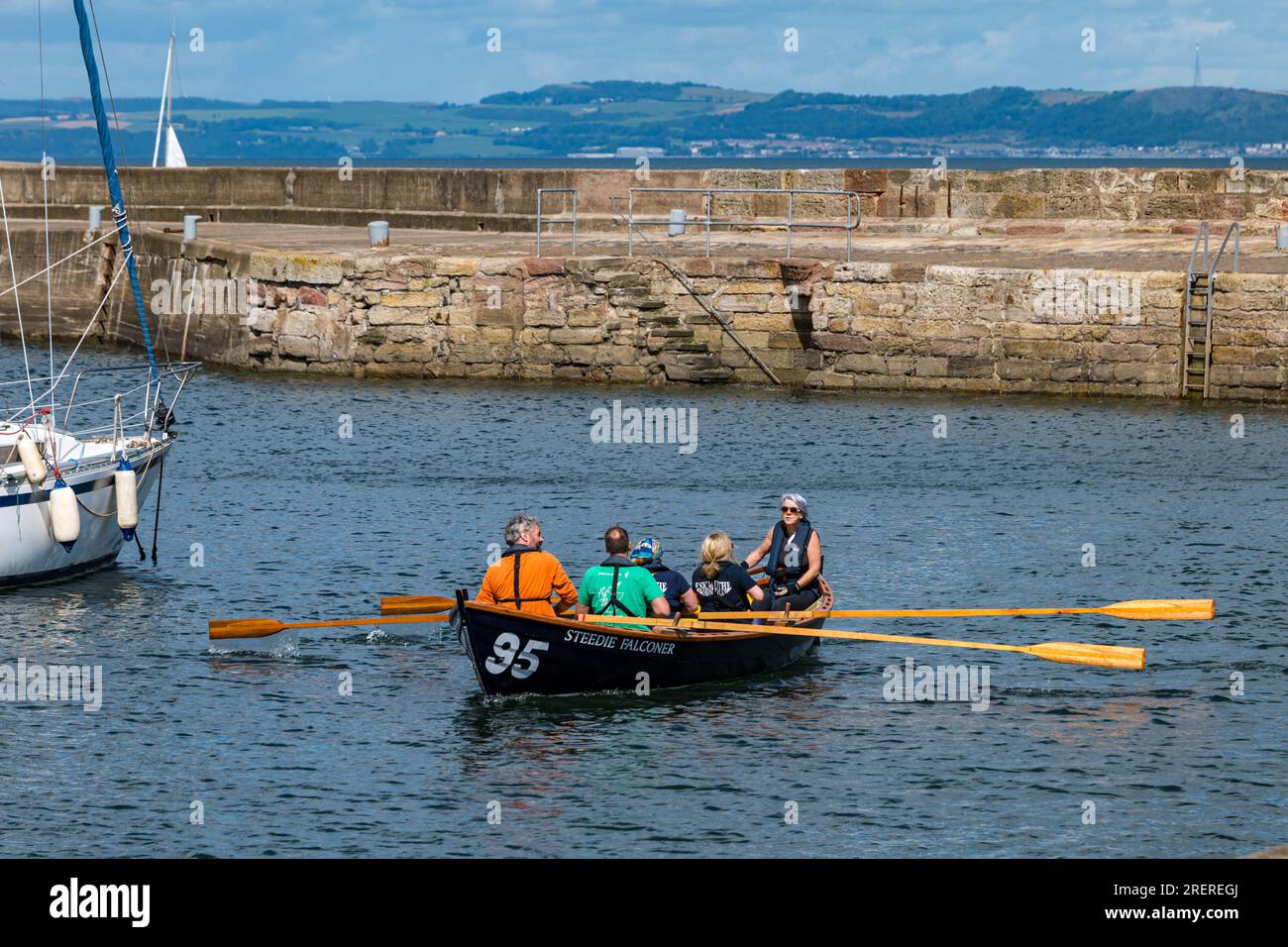 Gente a St Ayles canottaggio skiff, Fisherrow Harbour, Musselburgh, East Lothian, Scozia, REGNO UNITO Foto Stock