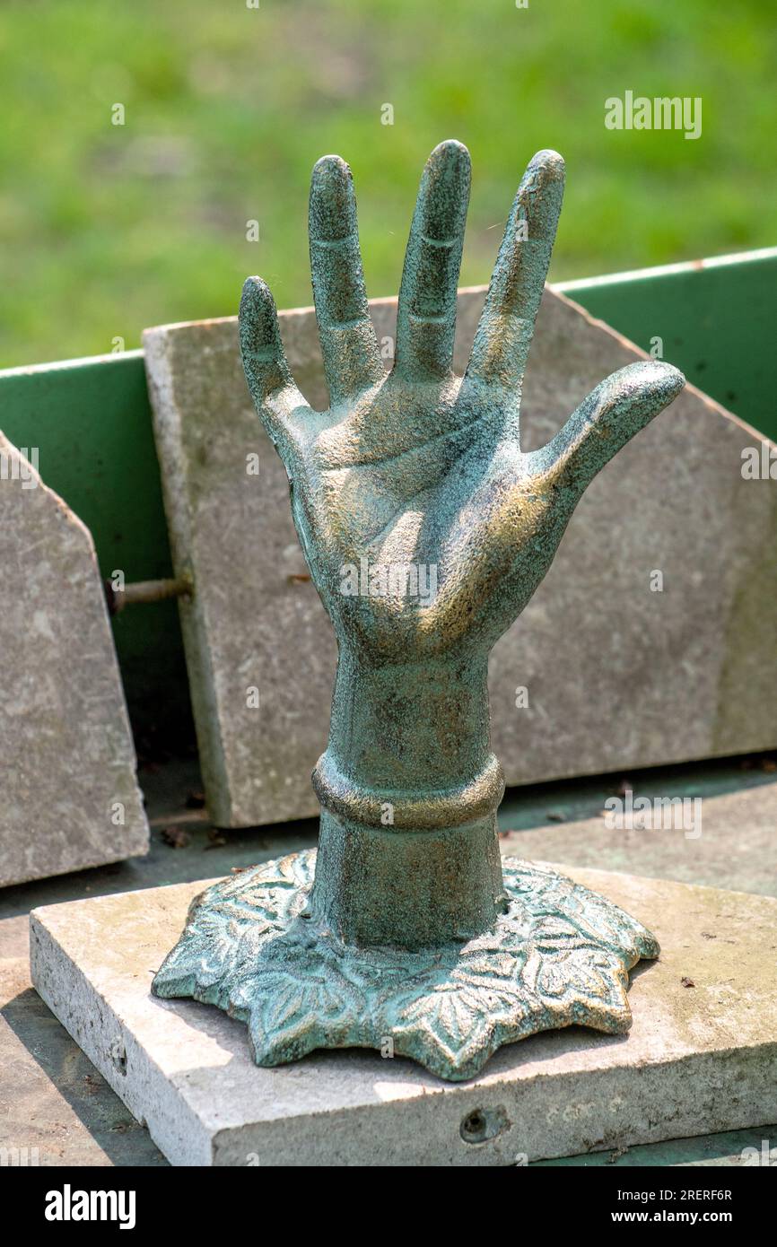 Una grande mano di metallo è in realtà una divertente scultura o un luogo in cui riporre gli anelli Foto Stock