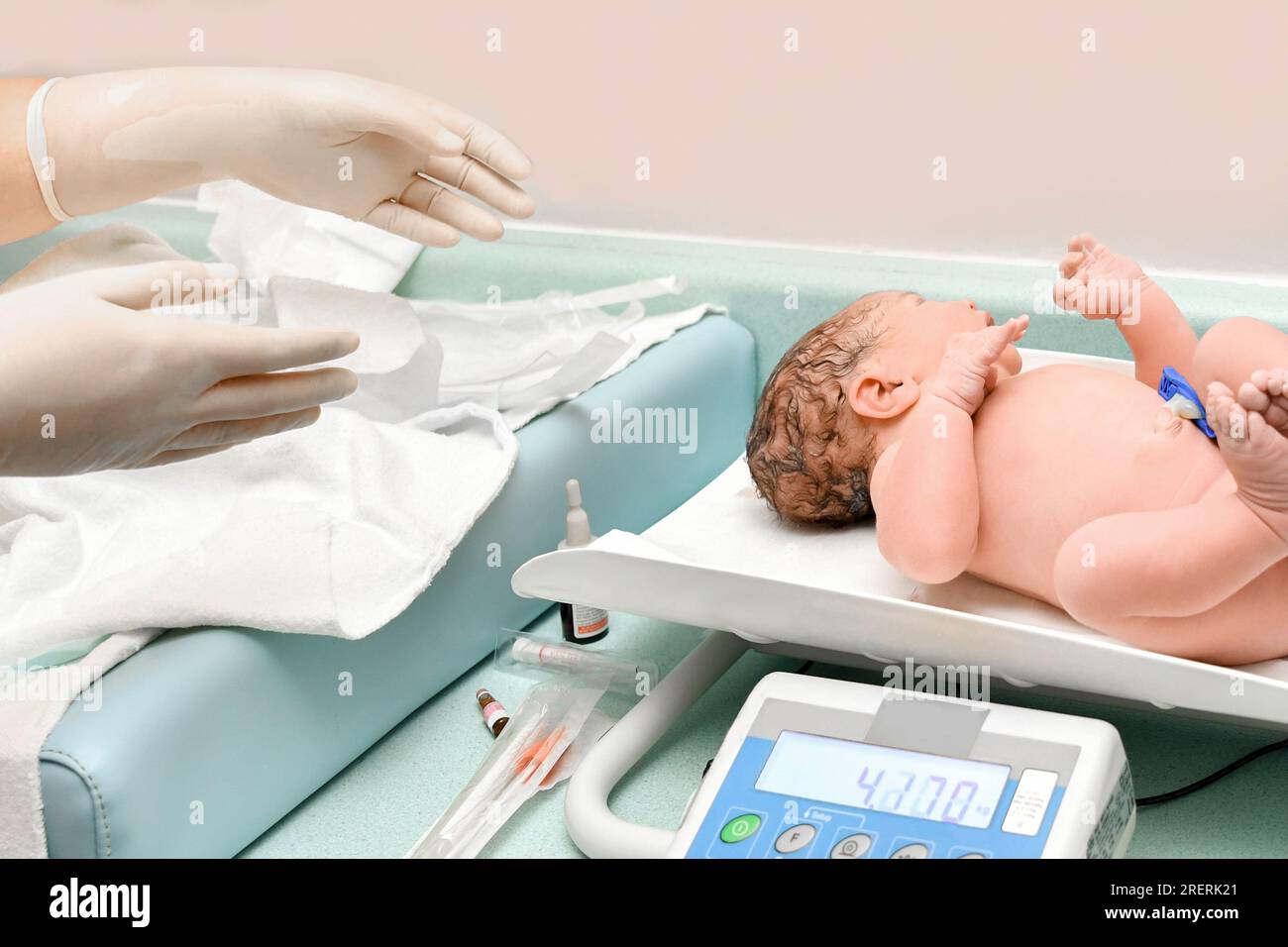 Un'infermiera pesa sulle bilance di un neonato Foto Stock