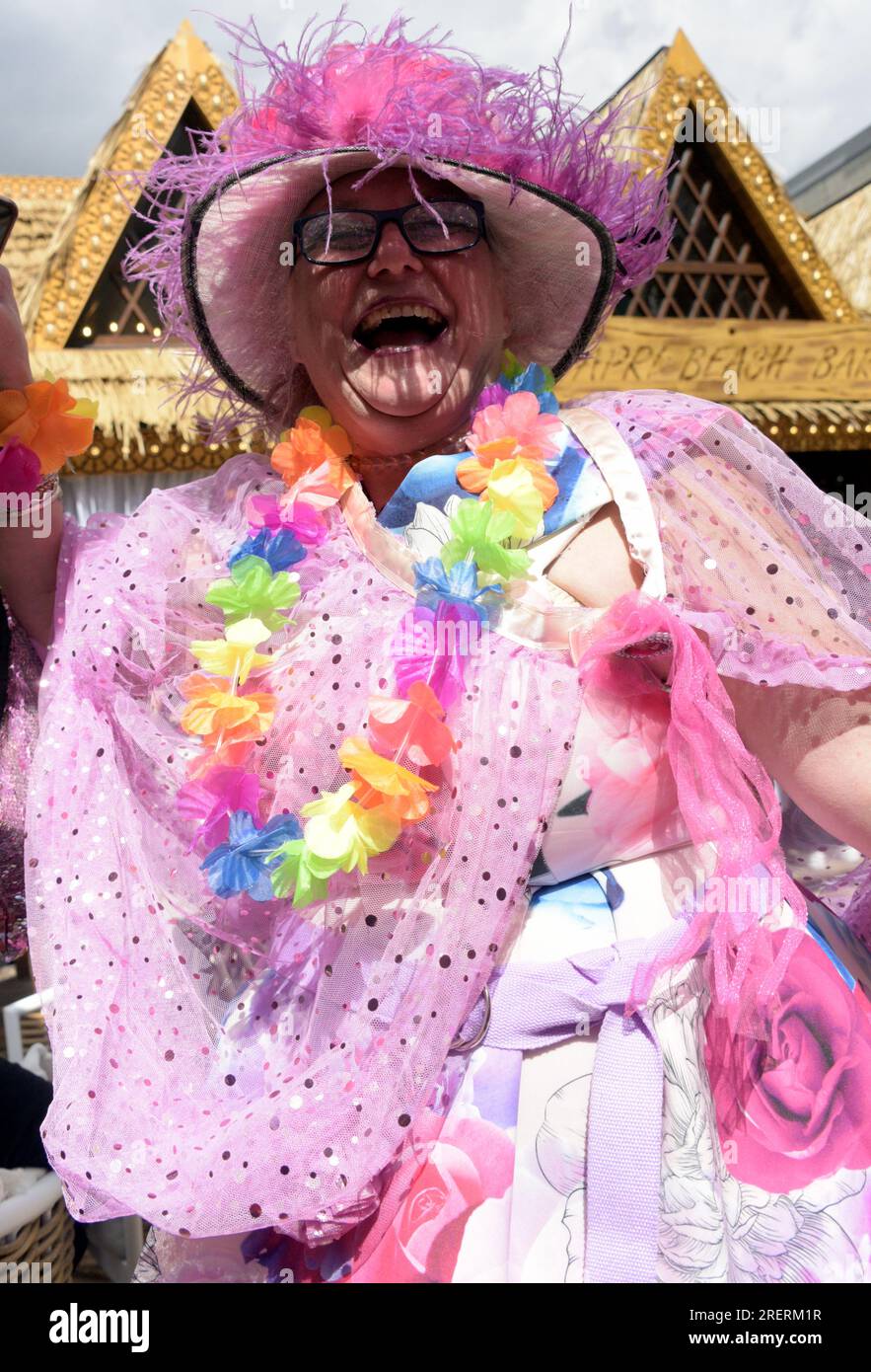 Manchester, Regno Unito, 29 luglio 2023. Un costume rosa vivace e colorato, con una collana arcobaleno, indossato da una persona che ama ballare al pop-up Capri Beach Bar, Exchange Square, Manchester, Regno Unito. Manchester Day - in vacanza!, gratuito, divertente, adatto alle famiglie, eventi per le strade del centro di Manchester, Regno Unito. Sostenuto dal Manchester City Council, Manchester Airport Group, Biffa, The Co-op, Manchester Evening News, Cammina sul Plank, il Regno dei dolci, il British Firefighter Challenge e il Capri Beach Club. Credito: Terry Waller/Alamy Live News Foto Stock