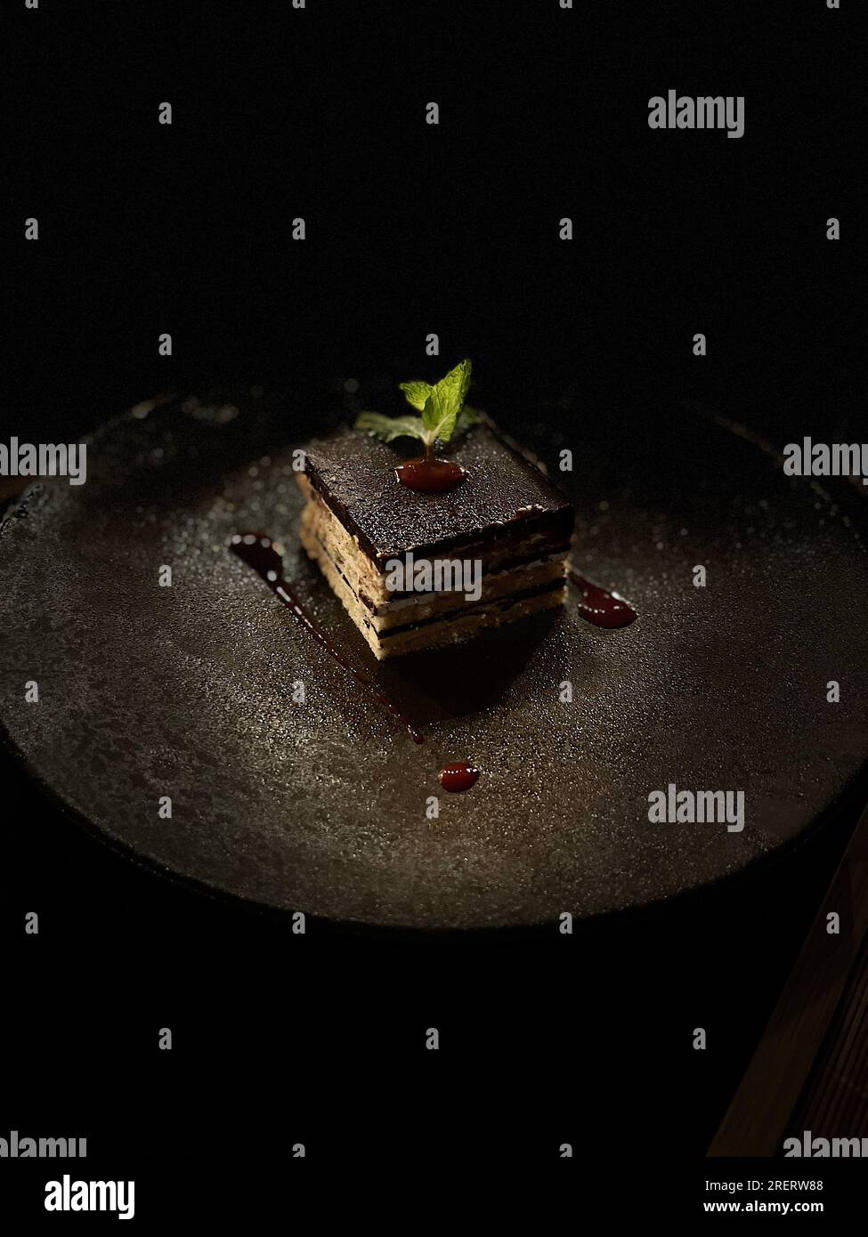 Il pezzo perfetto di torta al cioccolato, placcata professionalmente con sfondo scuro Foto Stock