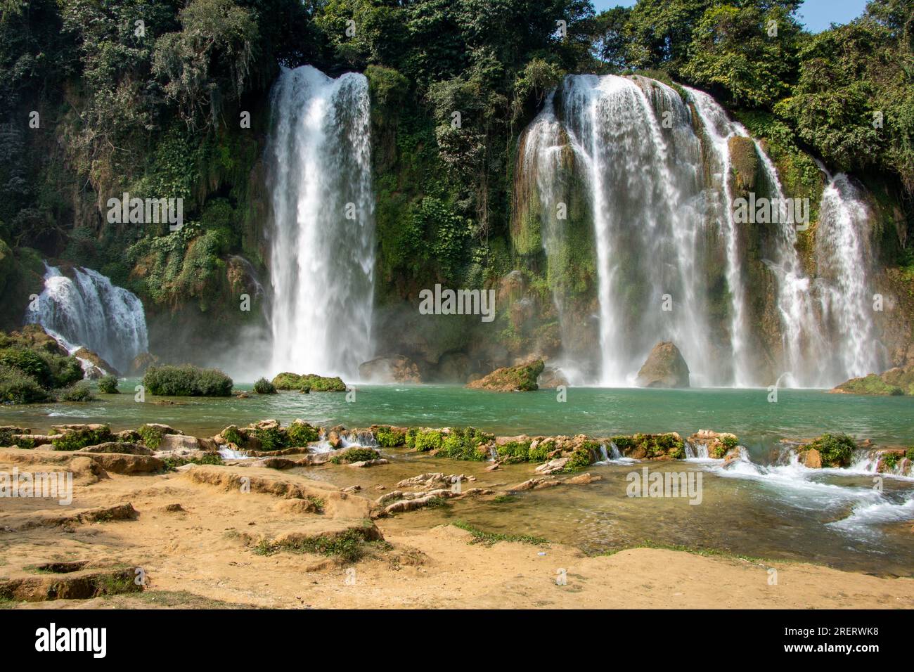 Cascate Ban Gioc-Detian al confine tra Vietnam e Cina in una splendida giornata, incorniciata da una foresta lussureggiante e da acque cristalline Foto Stock