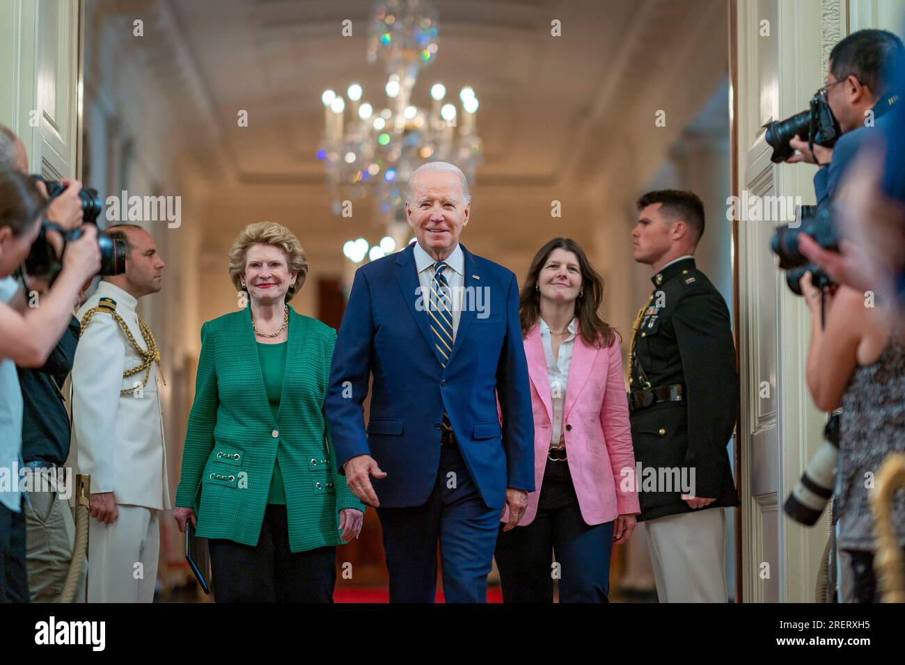 Washington, Stati Uniti d'America. 25 luglio 2023. Il presidente degli Stati Uniti Joe Biden, al centro, cammina con la senatrice Debbie Stabenow, D-Mich., a sinistra, e Richele Keas, a destra, Mentre arrivano per un evento nella East Room della Casa Bianca, il 25 luglio 2023 a Washington, D.C. Biden ha chiesto che le compagnie di assicurazione coprano i trattamenti di salute mentale. Credito: Adam Schultz/White House Photo/Alamy Live News Foto Stock