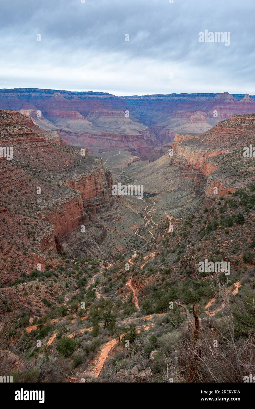 vista nuvolosa di un sentiero del Grand Canyon che si snoda attraverso rocce rosse. Foto Stock