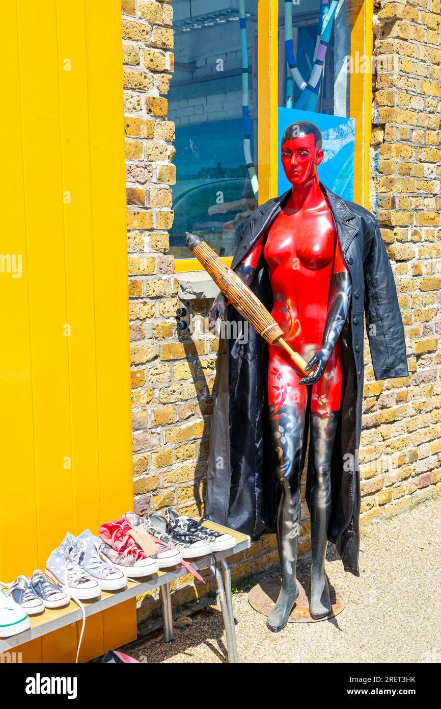 Manichino rosso che indossa un cappotto di pelle, regge l'ombrellone al Harbour Arm, Margate, Inghilterra Foto Stock