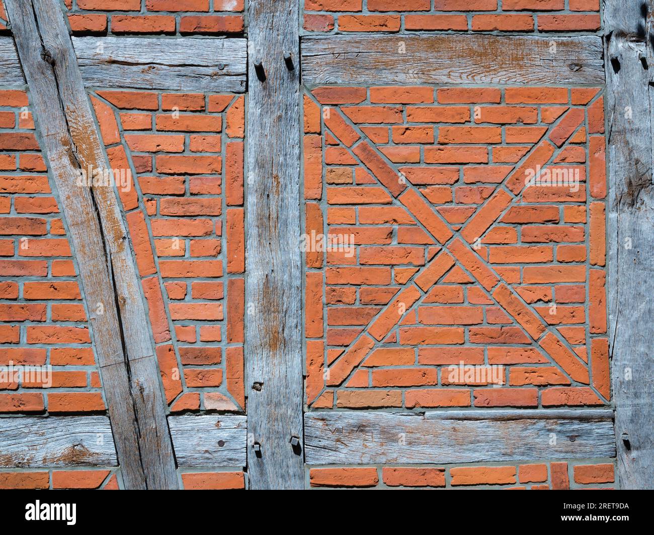 Vecchio muro in legno marrone, bricato con mattoni in diverse tonalità Foto Stock