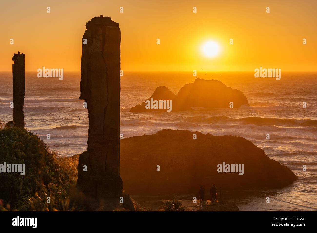 Colonne storiche che si stagliano contro il tramonto sull'oceano. Foto Stock