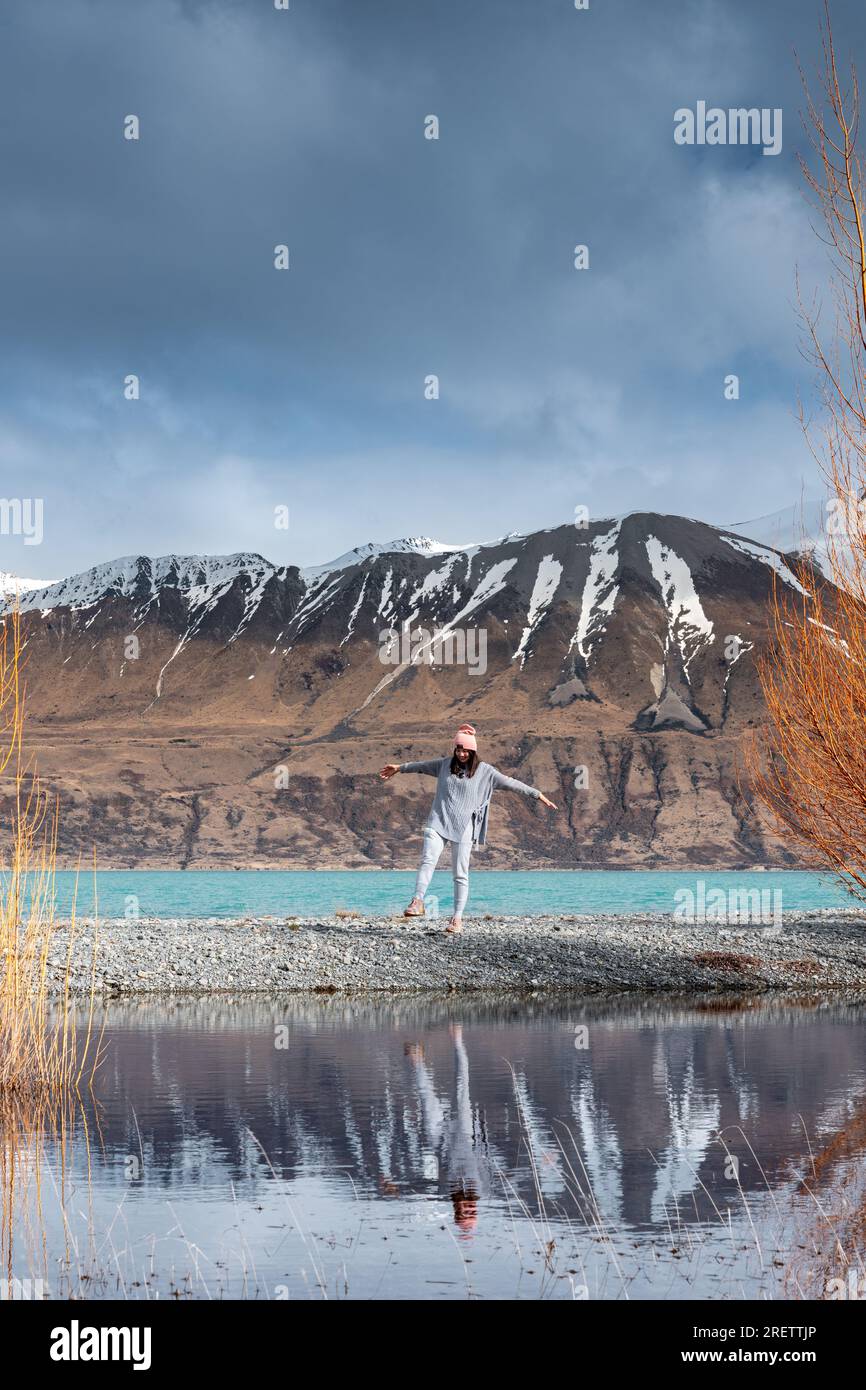 Modella asiatica femminile goditi la splendida vista panoramica dell'alba sulla sponda orientale del lago Pukaki, con la loro affascinante tonalità turchese. Foto Stock