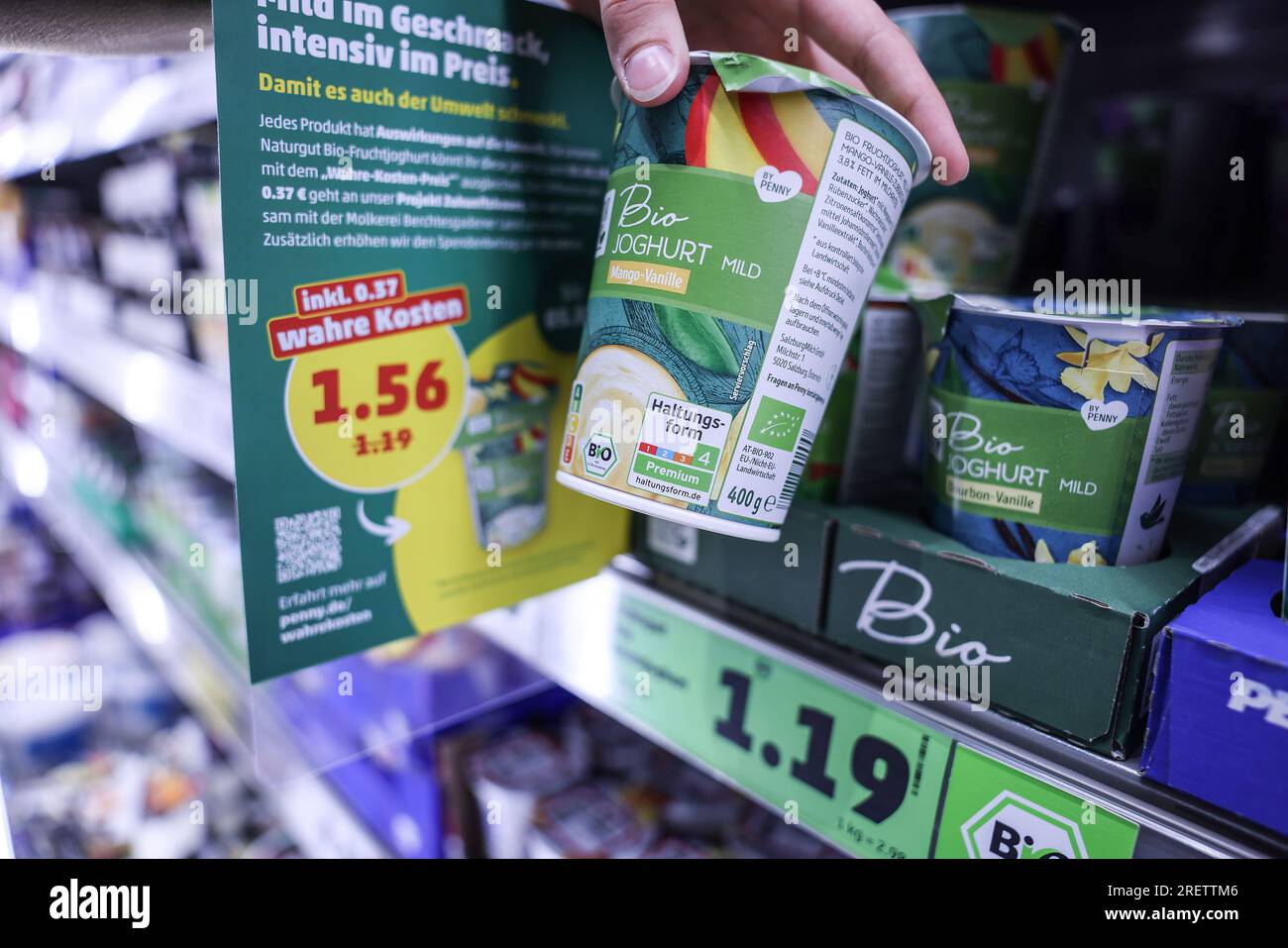 Colonia, Germania. 26 luglio 2023. Due cartellini di prezzo si aprono nella sezione refrigerata di fronte a una scatola di yogurt biologico. Penny fornisce uno shock di prezzo del suo genere da lunedì (31.0.07.2023). Per nove prodotti, l'azienda sta raccogliendo i "prezzi reali". Ciò tiene conto anche dei costi nascosti, ad esempio per l'inquinamento ambientale durante la produzione. (A dpa: "Discounter Experiment: How expensive food should actually be") credito: Oliver Berg/dpa/Alamy Live News Foto Stock