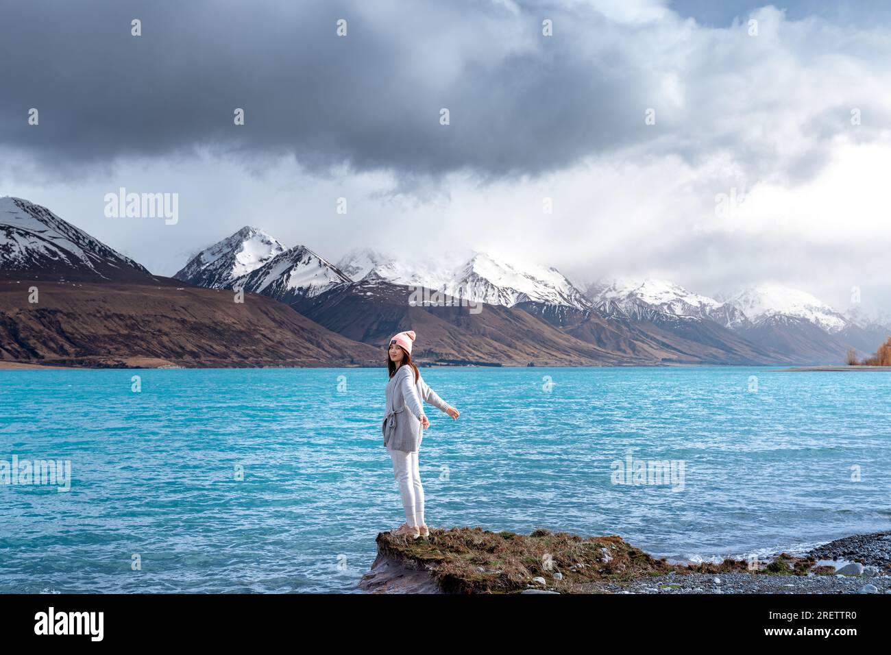 Modella asiatica femminile goditi la splendida vista panoramica dell'alba sulla sponda orientale del lago Pukaki, con la loro affascinante tonalità turchese. Foto Stock