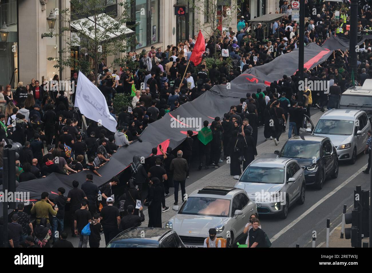 Londra, Regno Unito. 29 luglio 2023. La comunità musulmana sciita commemorò il sacrificio e il martirio dell'Imam Hussain nella processione annuale di Ashura attraverso il West End. Quest'anno, le copertine del corano appositamente stampate sono state distribuite ai partecipanti denunciando diverse ustioni del libro sacro in Danimarca e Svezia quest'anno, e chiedendo anche protezioni legali contro tali atti. Credito: Fotografia dell'undicesima ora/Alamy Live News Foto Stock