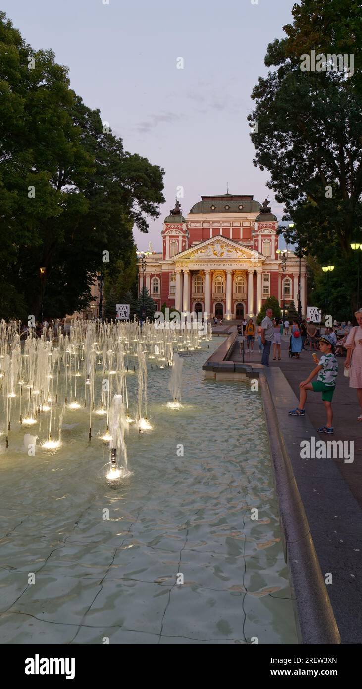 Ivan Vazov National Theatre, situato nell'area dei giardini della città, con fontana e visitatori, Sofia, Bulgaria. 29 luglio 2023 Foto Stock