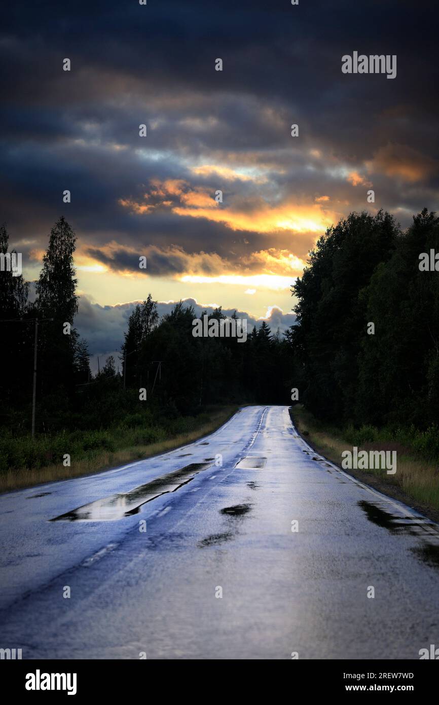 Autostrada vuota dopo la pioggia con un cielo lungoso di sera. Foto Stock
