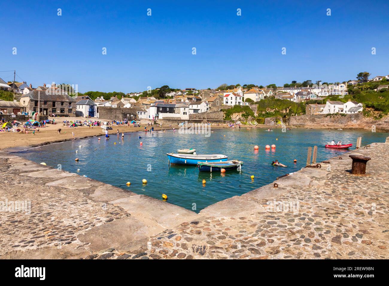 28 maggio 2023: Gorran Haven, Roseland Peninsula, Cornovaglia, Regno Unito - il porto interno di Gorran Haven, con persone, spiaggia, barche ed edifici sul porto, Foto Stock