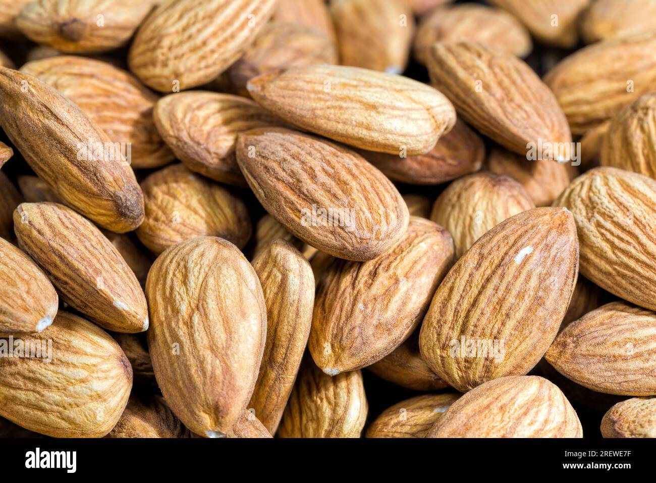 Mandorle che vengono utilizzate per il cibo e per la cottura di vari piatti, mandorle dure crude pronte da mangiare, noci dorate utili e ricche di proteine e minatori Foto Stock