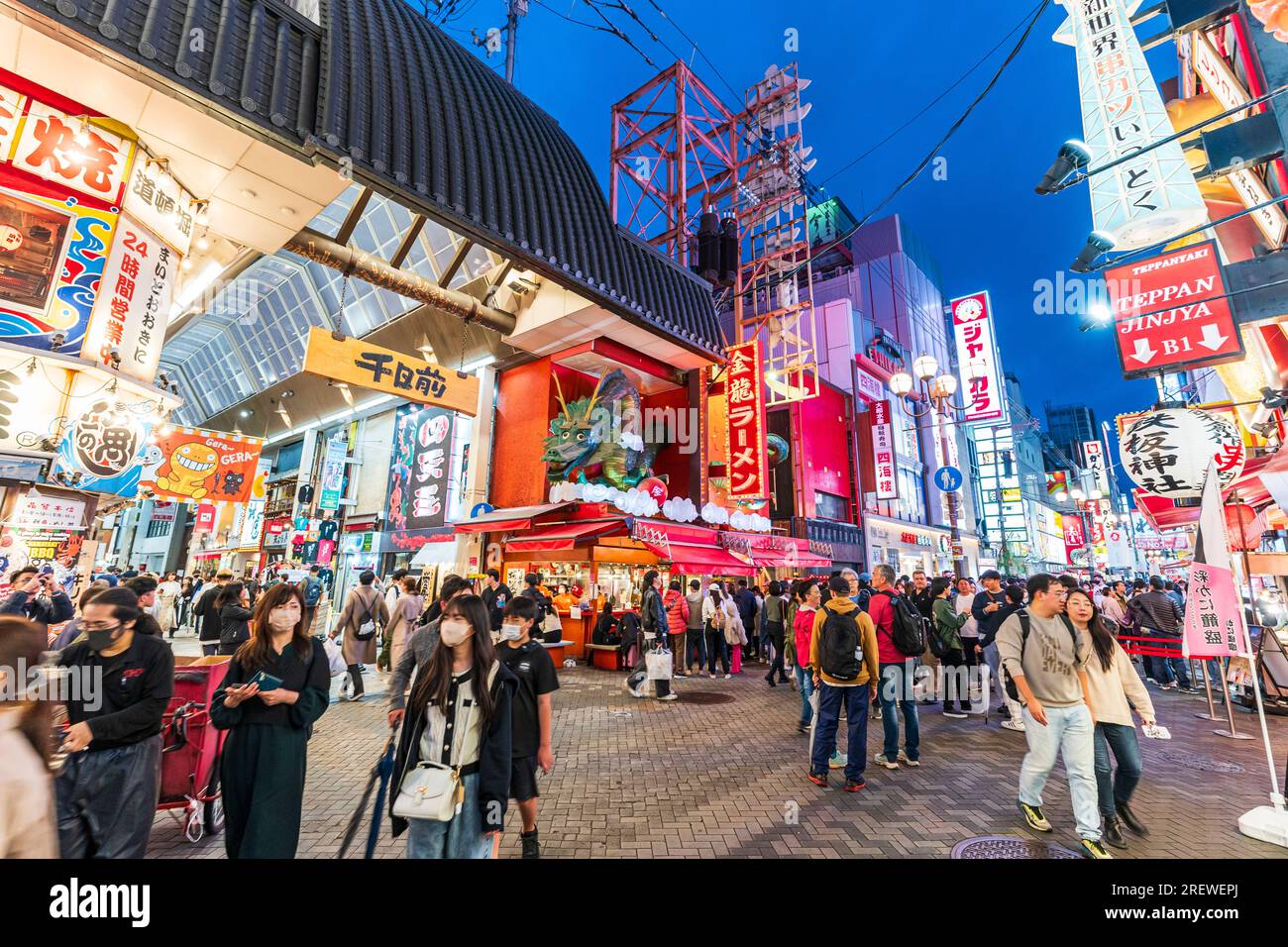 Movimentata scena notturna all'entrata di Sennichimae Street con il famoso ristorante Kinryu Ramen all'angolo a Dotonbori in Osaka. Foto Stock