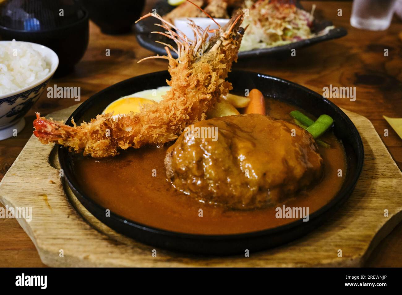 Luglio 2023, Un piatto caldo giapponese composto da una tempura di gamberi, un hamburger giapponese (hambagu), uova fritte e verdure Foto Stock