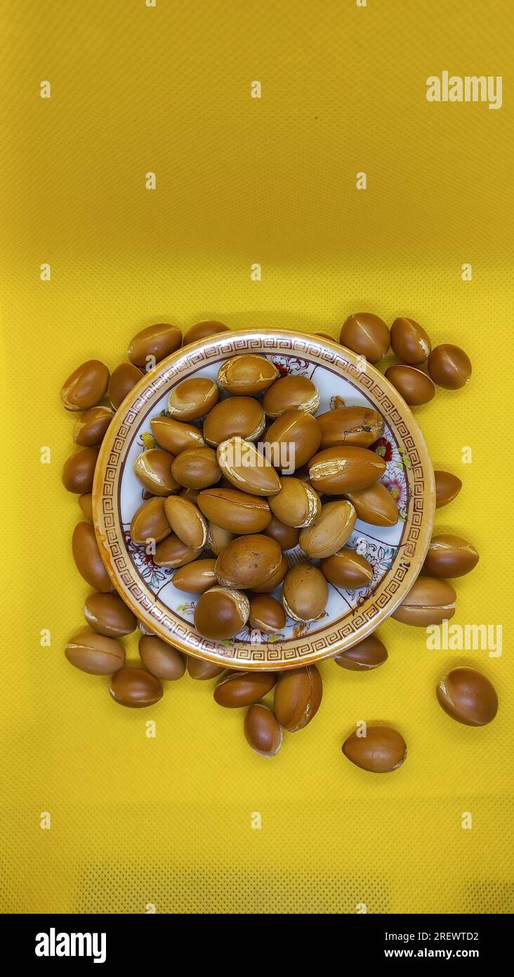 Alcuni semi di Argan su sfondo giallo Foto Stock