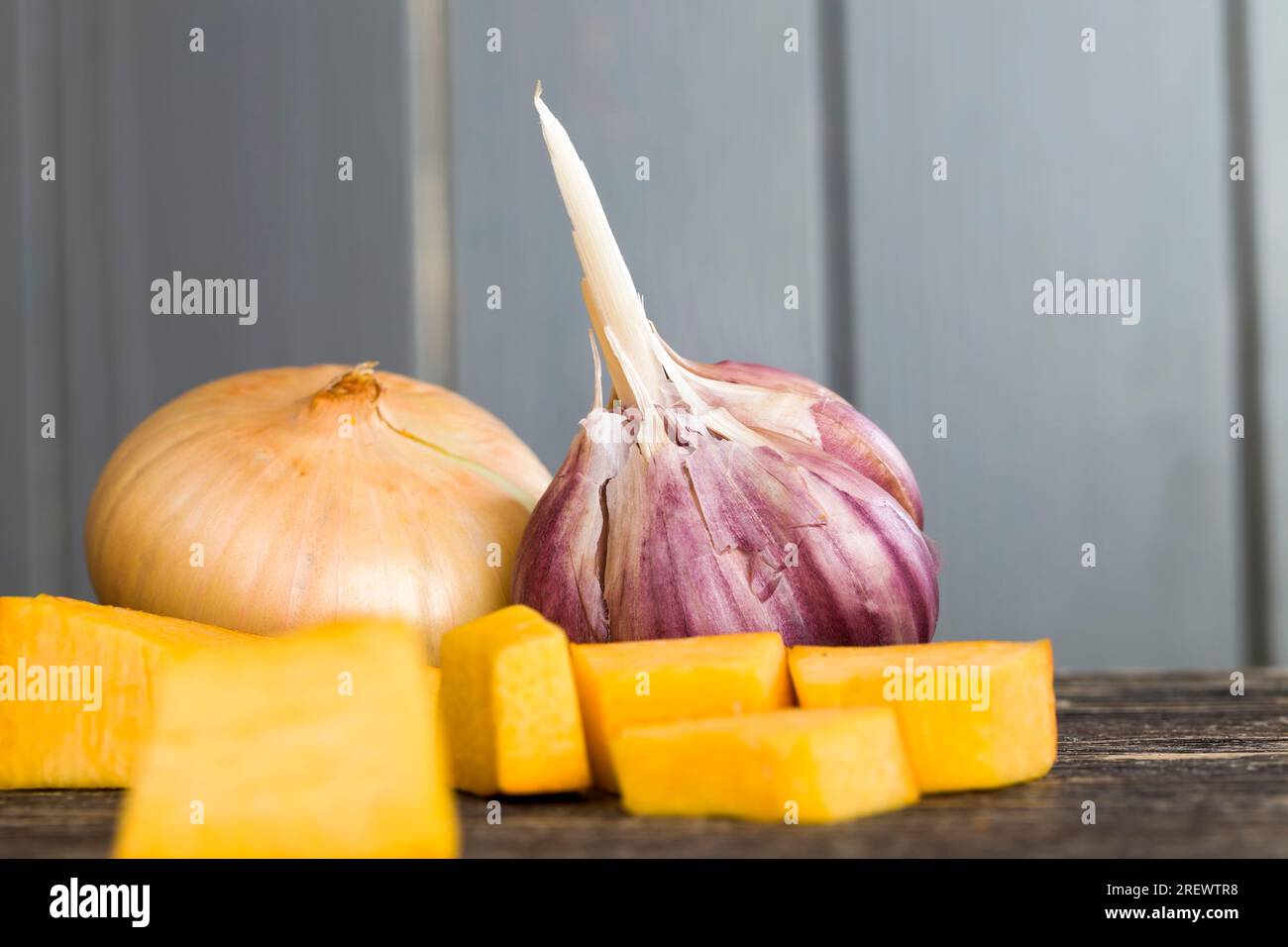 Zucca di verdure mentre cucinano i piatti vegetariani, zucca d'arancia dolce divisa in pezzi su un tagliere in cucina per cucinare, primo piano Foto Stock