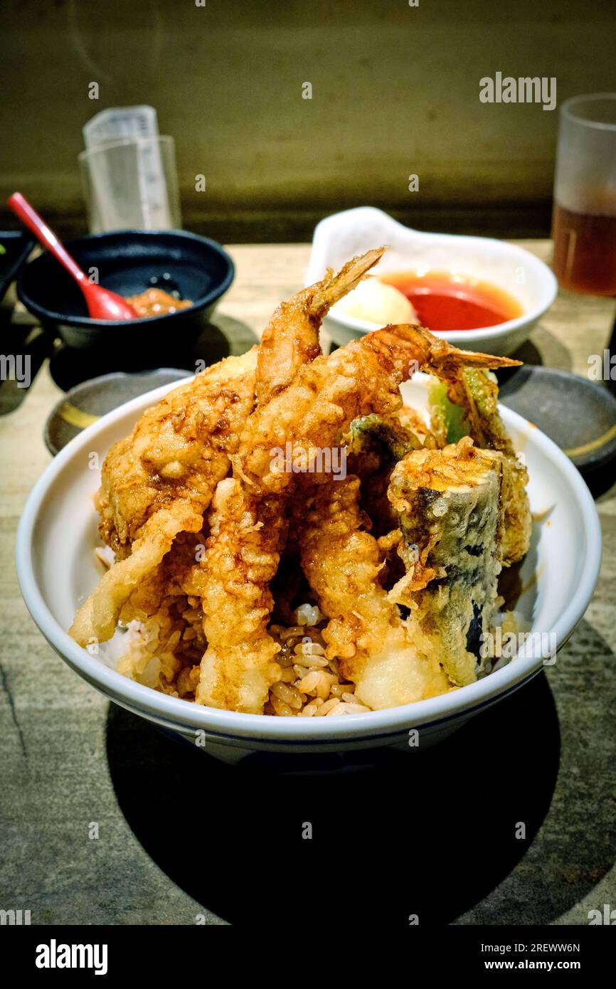 Luglio 2023, Una ciotola di riso tempura (tendine) con vari condimenti, composta da gamberoni leggermente impastati e fritti in profondità, uova e verdure Foto Stock