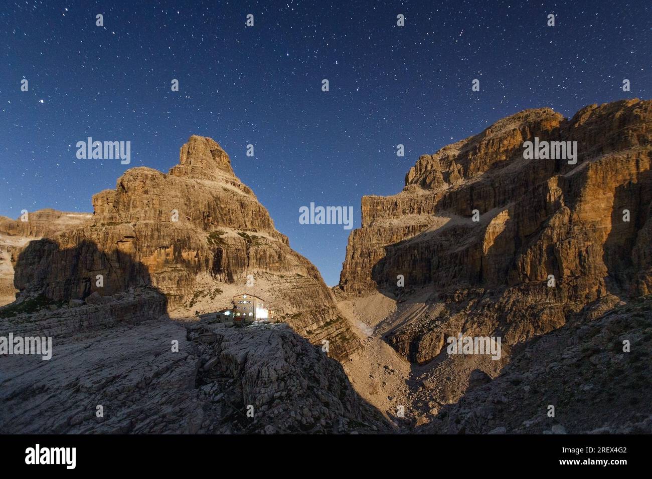 Il chiaro di luna mentre sale. Cielo stellato. Le Dolomiti di Brenta. Cima Brenta alta e bassa. Luci del rifugio Tosa Pedrotti. Trentino. Alpi italiane. Europa. Foto Stock