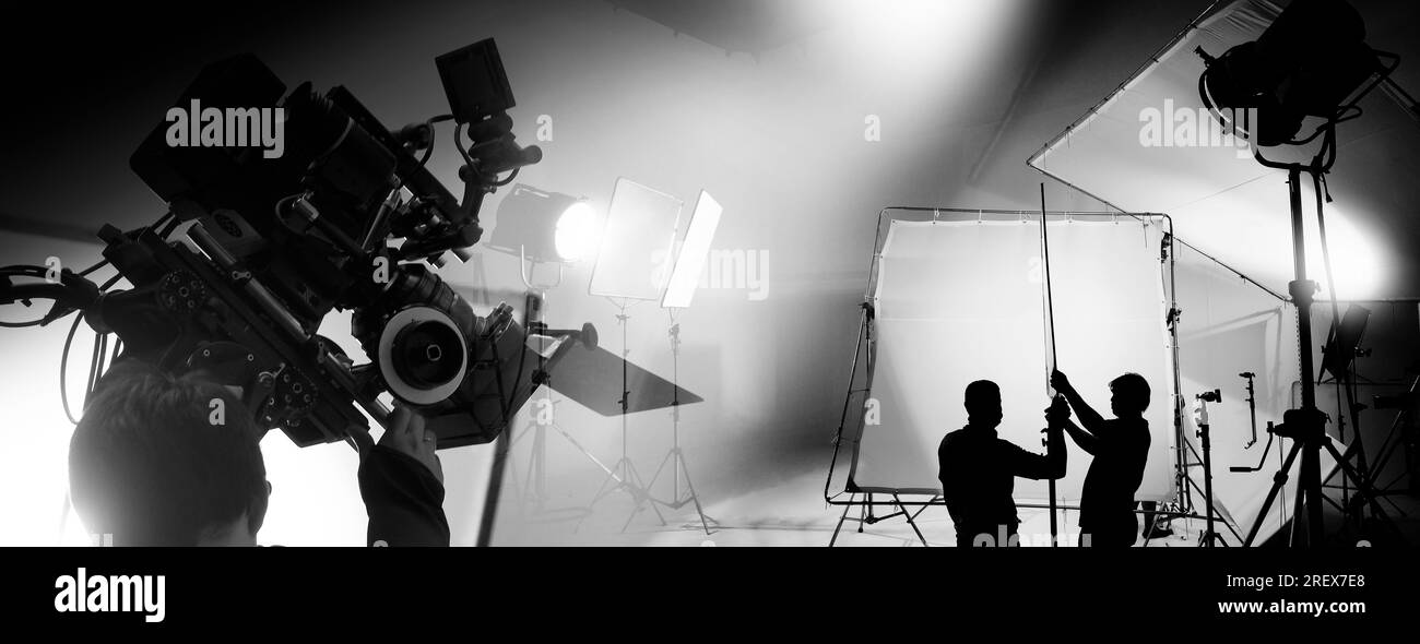 Silhouette di produzione video dietro le quinte o B roll o realizzazione di film commerciali televisivi che la troupe di film lightman e cameraman lavorano insieme Foto Stock