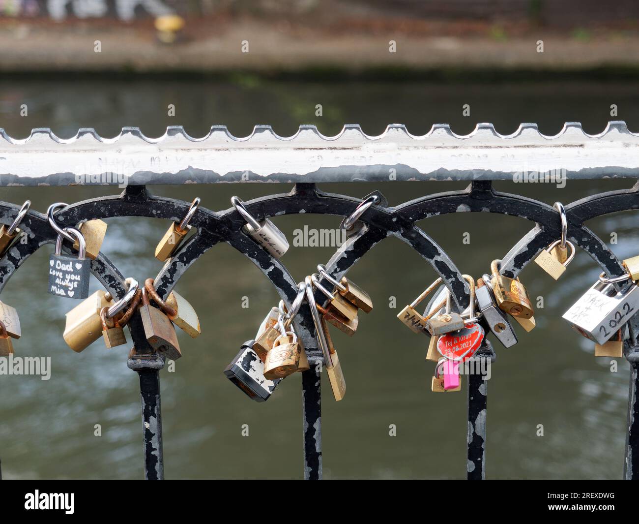 Vista ravvicinata dei lucchetti con messaggi sentimentali attaccati alle ringhiere metalliche lungo il canale a Camden Lock a Londra, Regno Unito Foto Stock