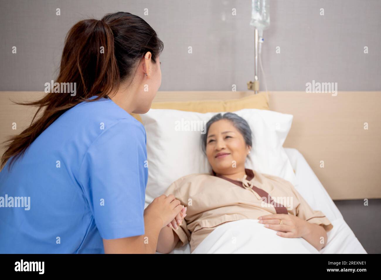 Medico donna incoraggiare con paziente anziano in ospedale, medico o infermiere prendersi cura e tenersi per mano per consolare anziani malati, disi diagnostica Foto Stock