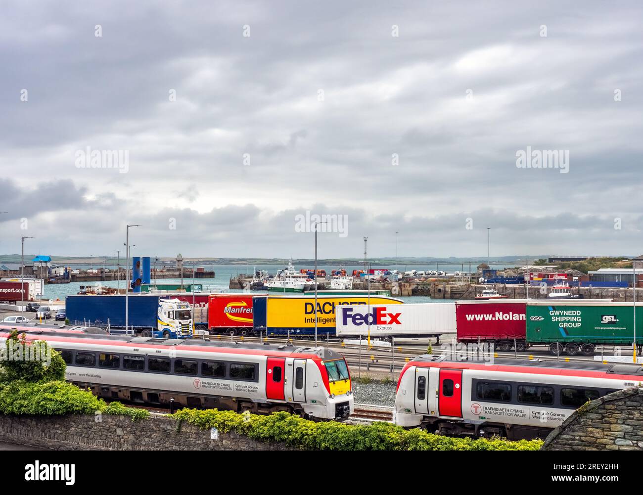 Molo del porto interno di Holyhead Port che mostra container di spedizione sulla rotta commerciale Regno Unito-Irlanda (dopo la Brexit) e anche unità ferroviarie locali. Foto Stock