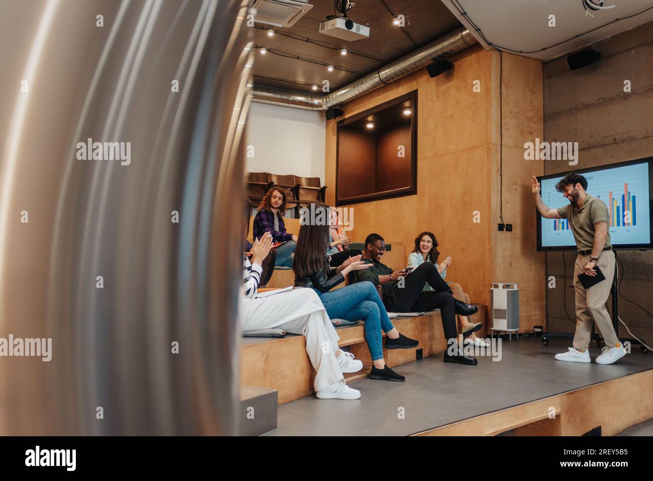 Gli uomini d'affari che si divertono al lavoro durante il brainstorming in un piccolo anfiteatro, discutono, pianificano e scherzano Foto Stock