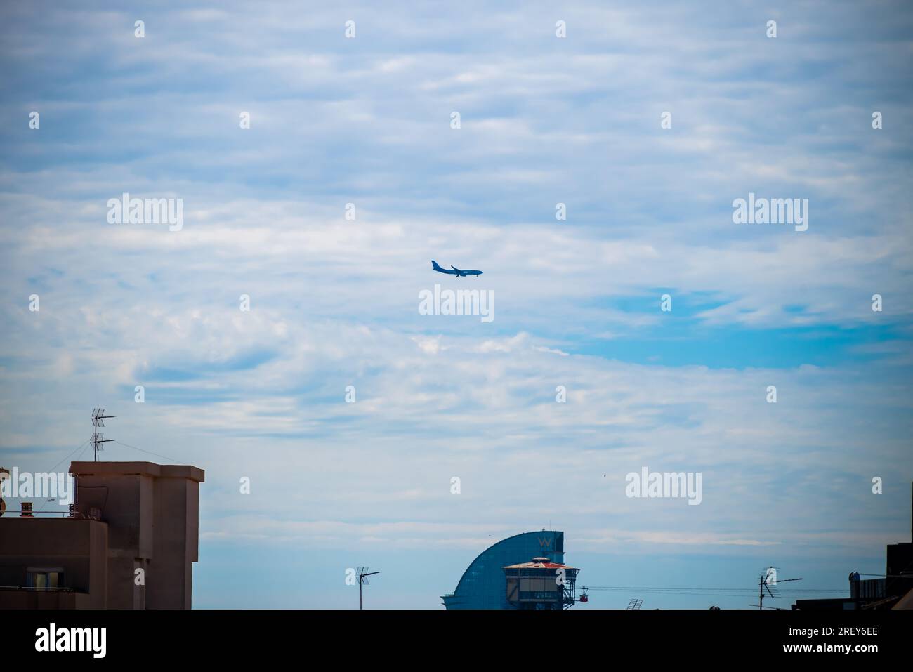Barcellona, Spagna - maggio 26 2022: L'aereo vola sopra i tetti in direzione dell'aeroporto internazionale di Barcellona. Foto Stock