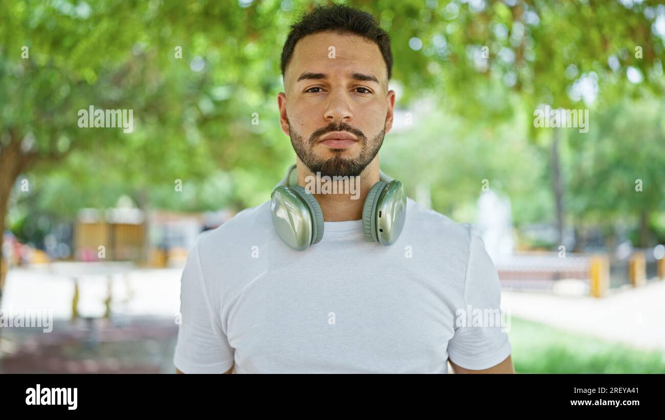 Giovane arabo che indossa cuffie al parco Foto Stock