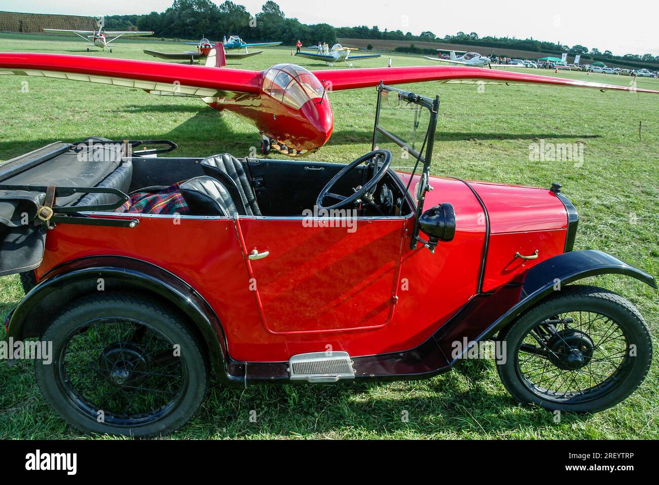 1928 Austin Seven Tourer con 1930s Slingsby T.13 Petrel a Wings & Wheels fly-in all'aerodromo di Turweston, Buckinghamshire, Regno Unito. Era britannica pre-bellica Foto Stock