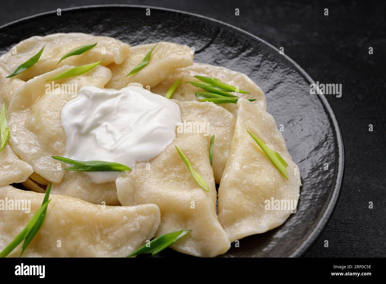 Gnocchi ucraini bolliti su sfondo scuro Foto Stock