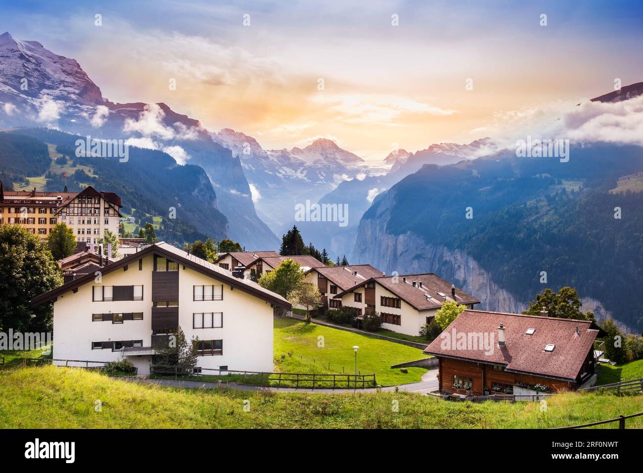 Città di Wengen in Svizzera al tramonto. Vista sulle Alpi svizzere vicino alla valle di Lauterbrunnen. Tipiche case svizzere a Wengen. Cime montuose di Eiger e. Foto Stock