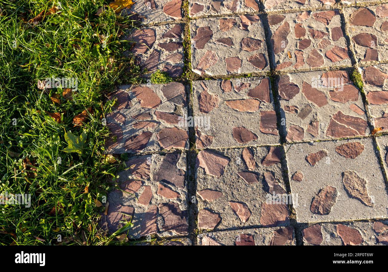 Parte della strada pedonale è fatta di pietre rosse collegate da cemento, la parte decorativa della strada è utilizzata per camminare Foto Stock
