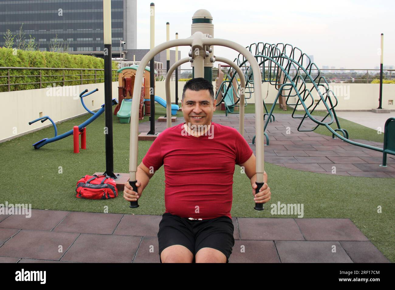 L'uomo latino-americano dai capelli scuri, 40 anni, si esercita sul giardino pensile del suo condominio per prevenire sovrappeso, diabete e ipertensione Foto Stock