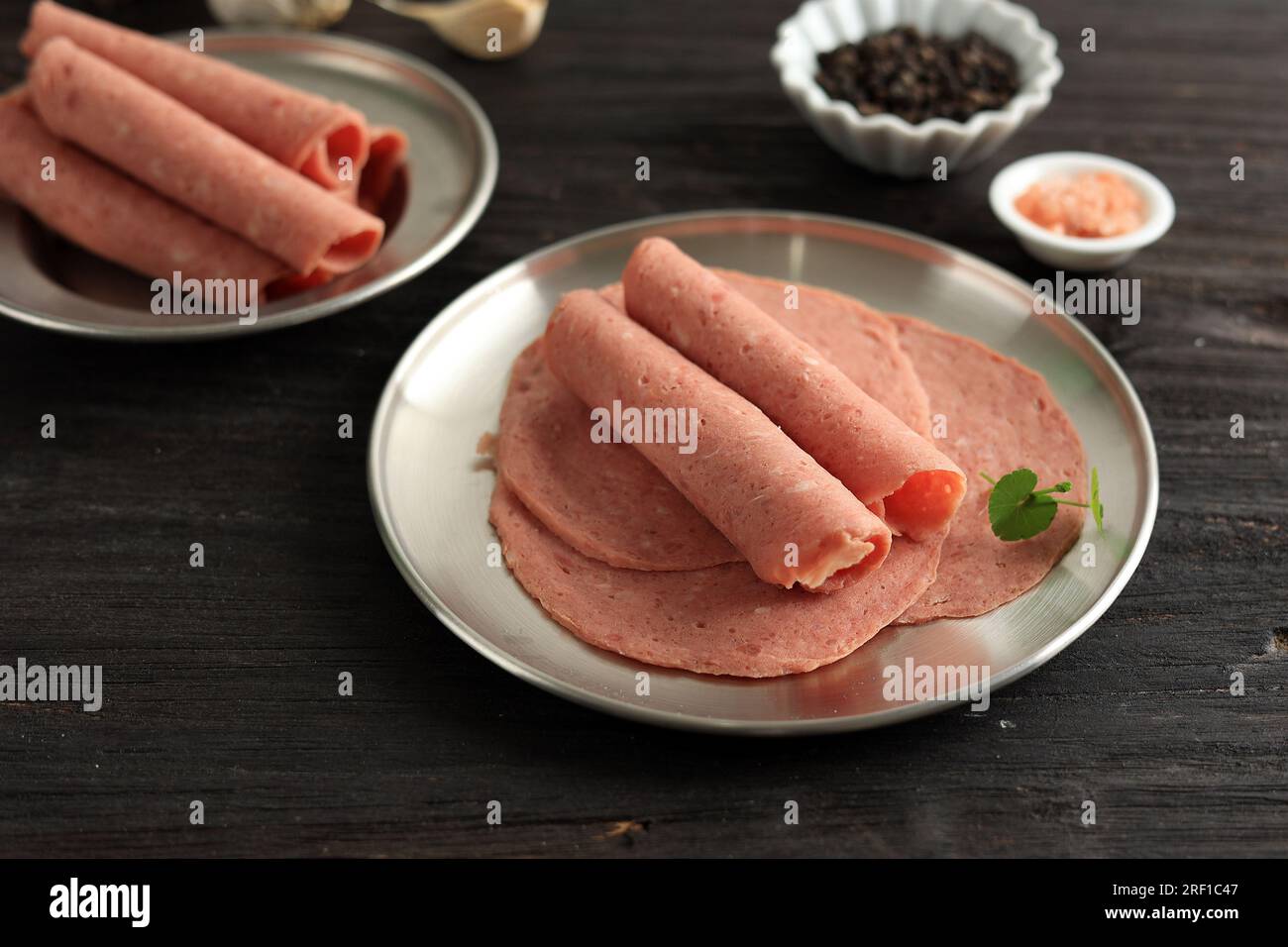 Salame di manzo affumicato, salsiccia sottile a fette su tavola di legno Foto Stock