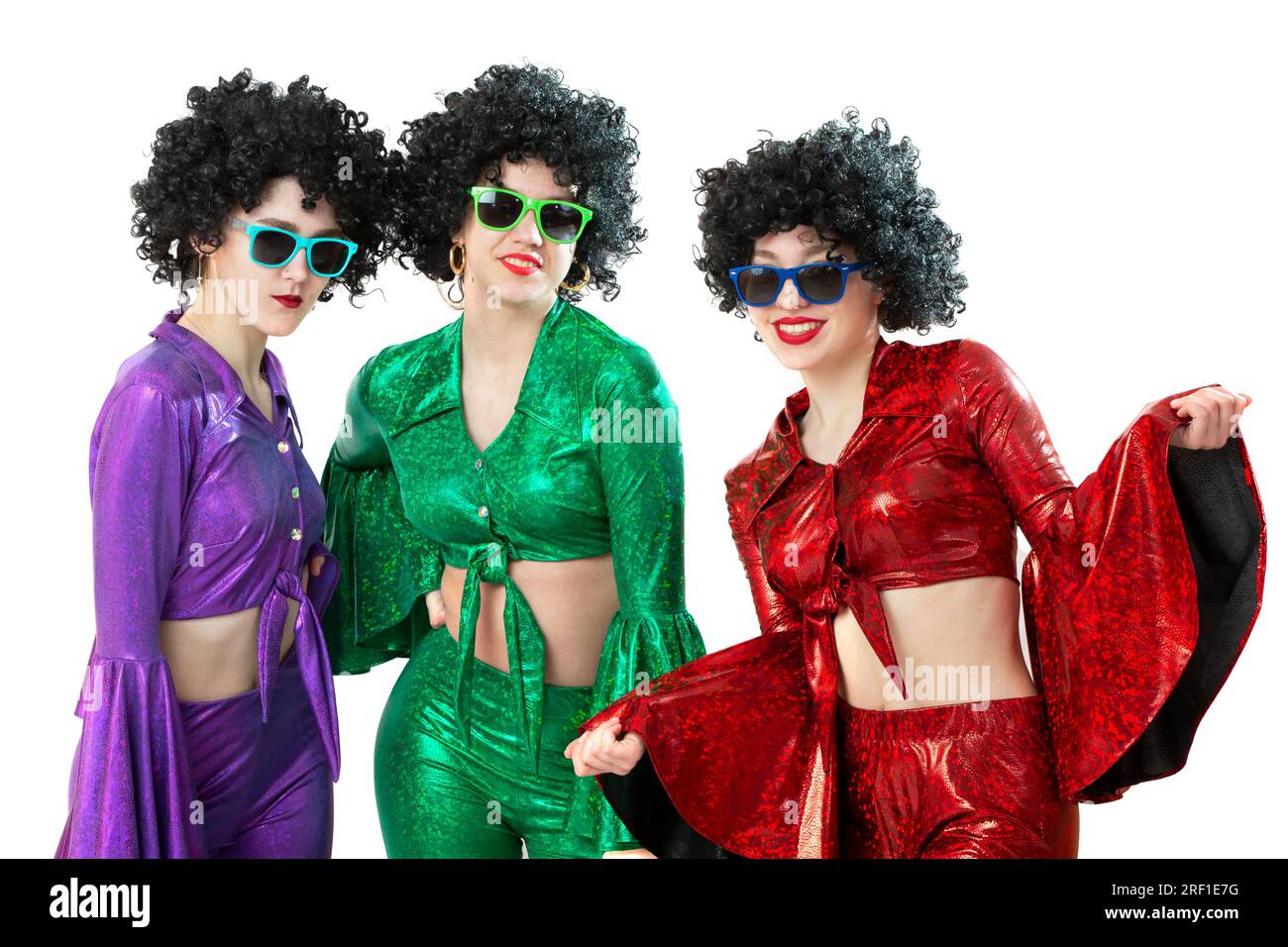 Un gruppo di ragazze da discoteca con parrucche afroamericane e costumi colorati su sfondo bianco. La moda degli anni Settanta e Ottanta. Foto Stock